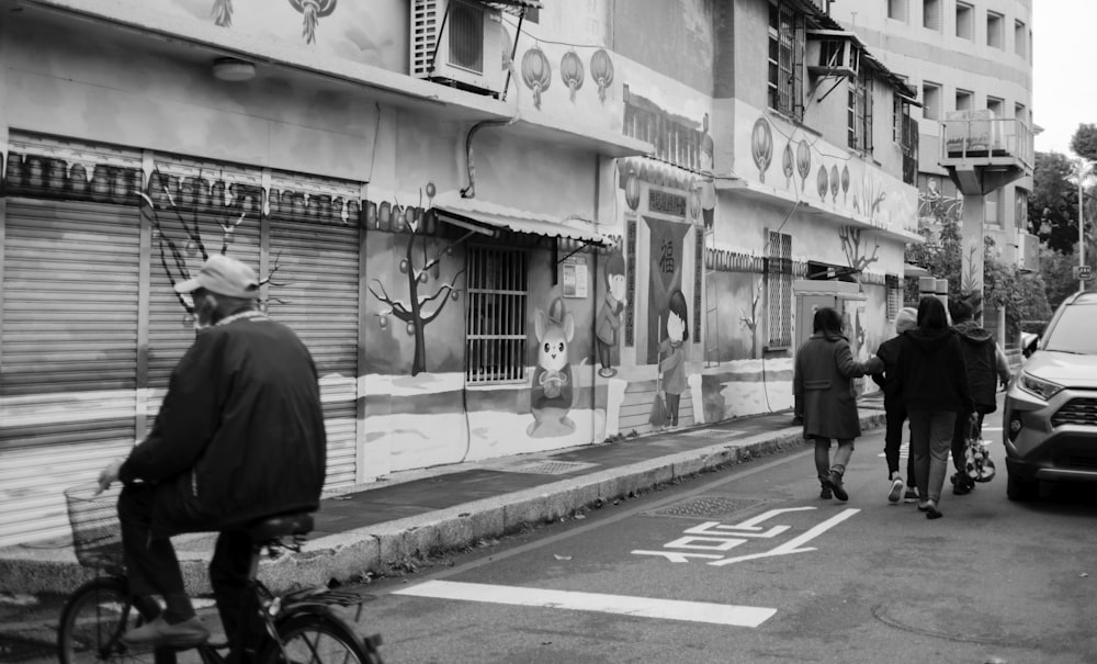 grayscale photo of man walking on sidewalk