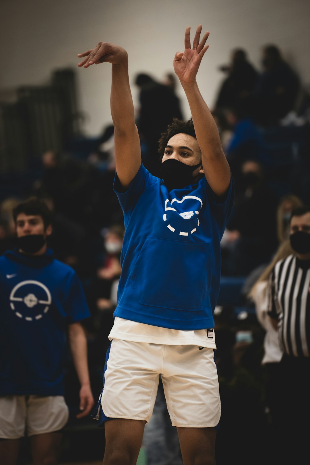 man in blue and white adidas soccer jersey shirt raising his hands