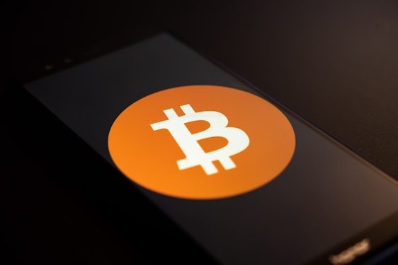 Close-up of hands holding a smartphone displaying a Bitcoin wallet app.