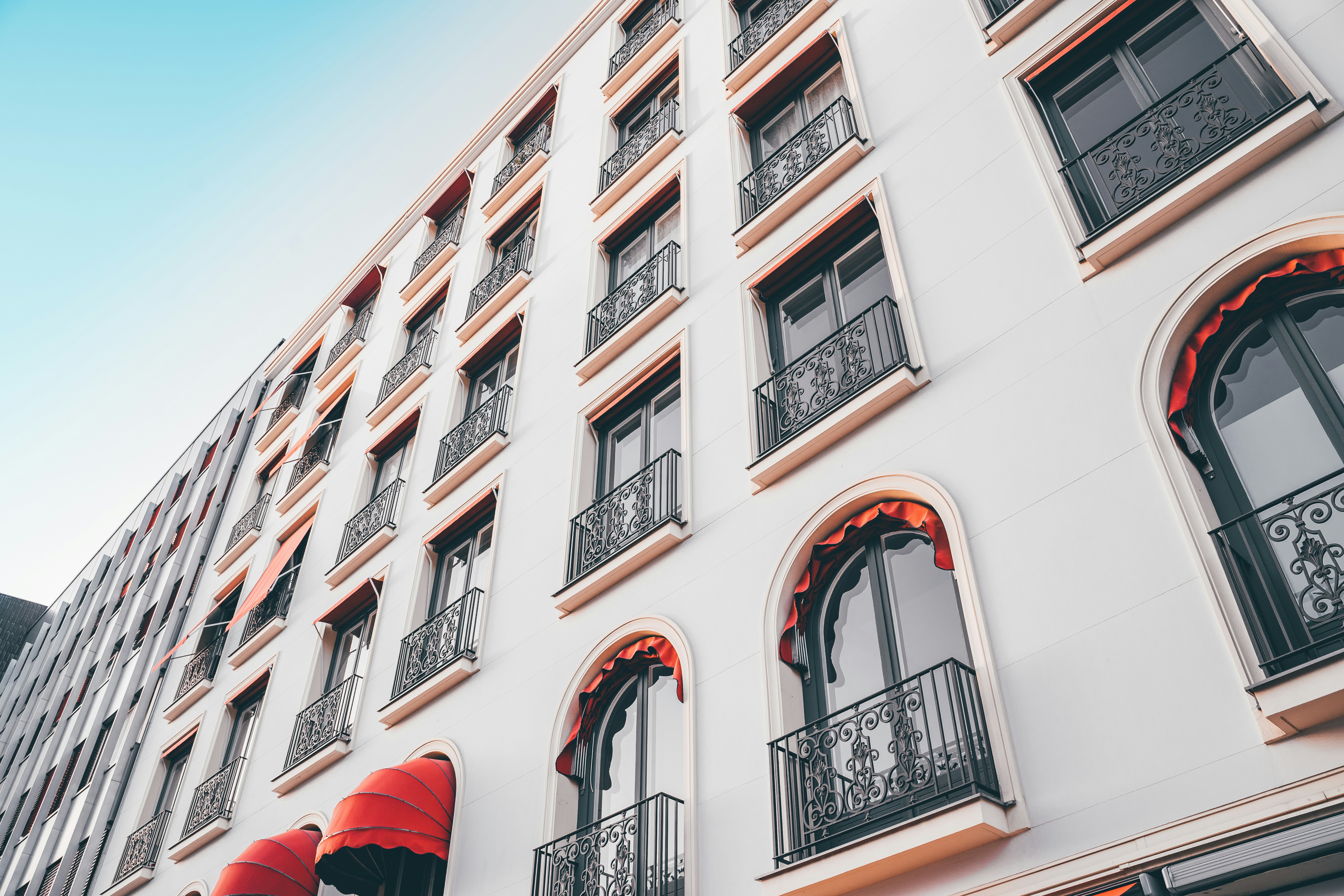 Roter Regenschirm in der Nähe von weißem Betongebäude