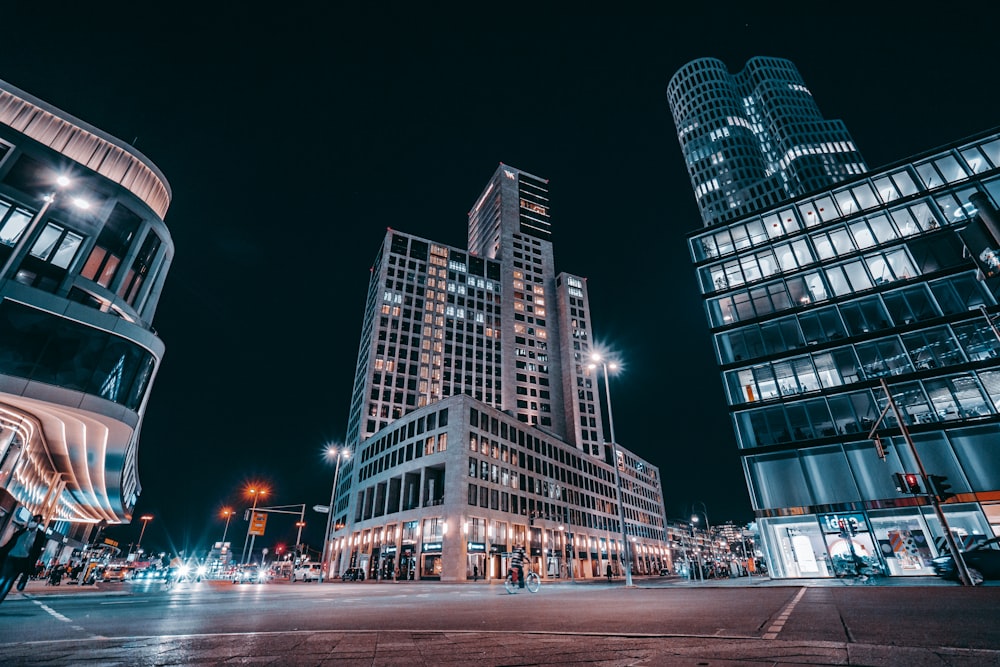 people walking on street near high rise building during night time