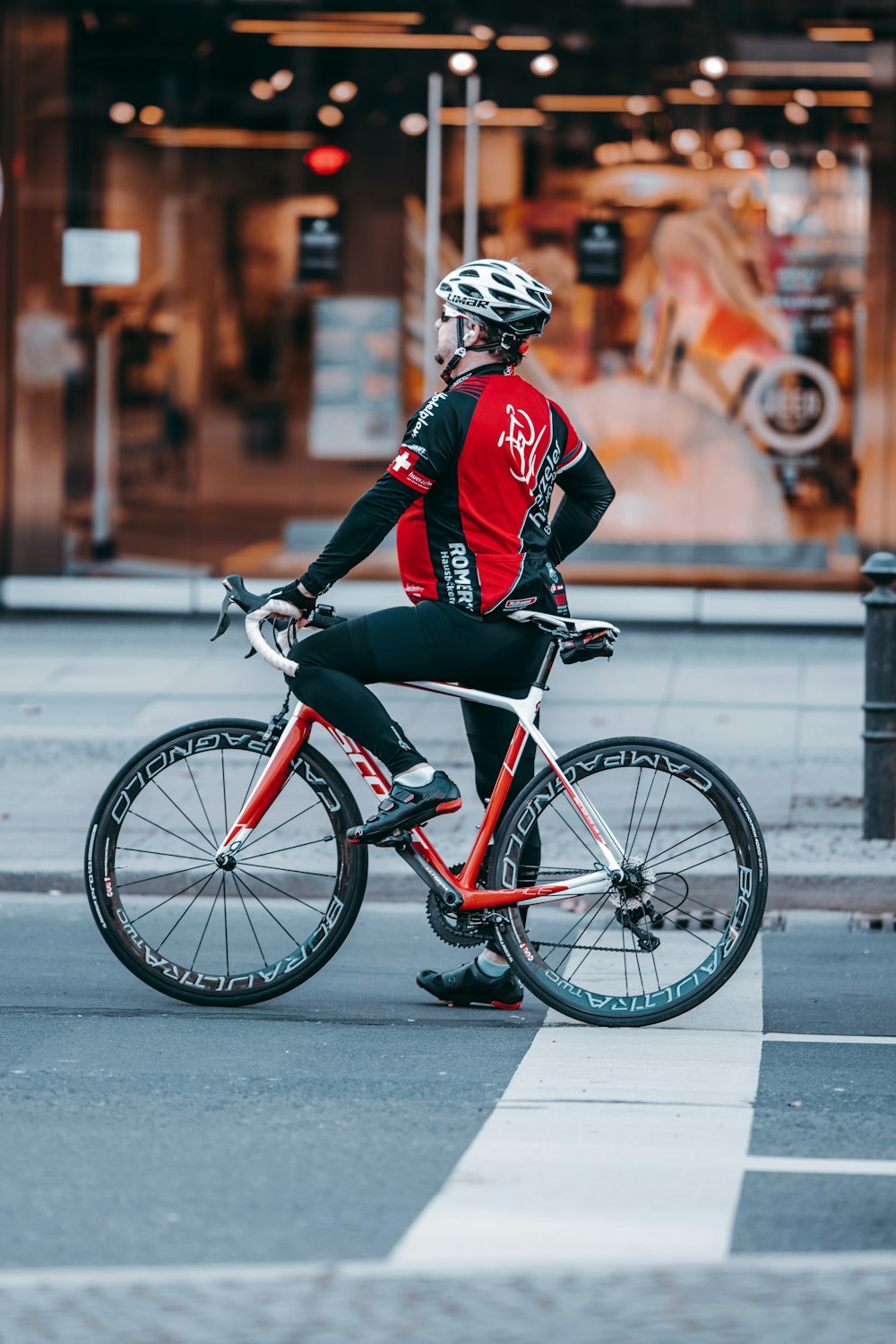 man in red and black jacket riding on bicycle