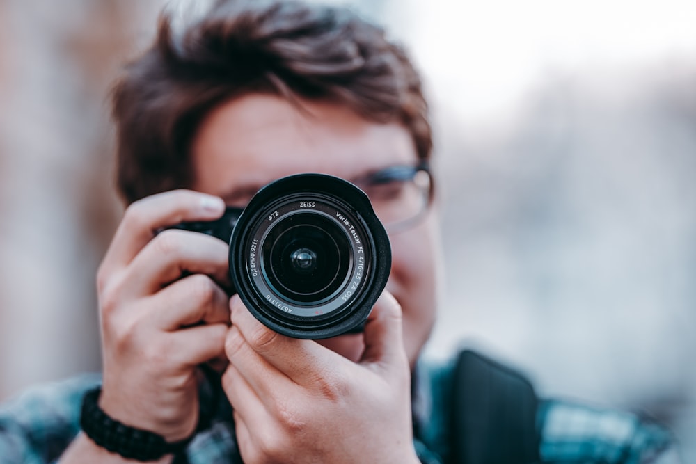 person holding black camera lens