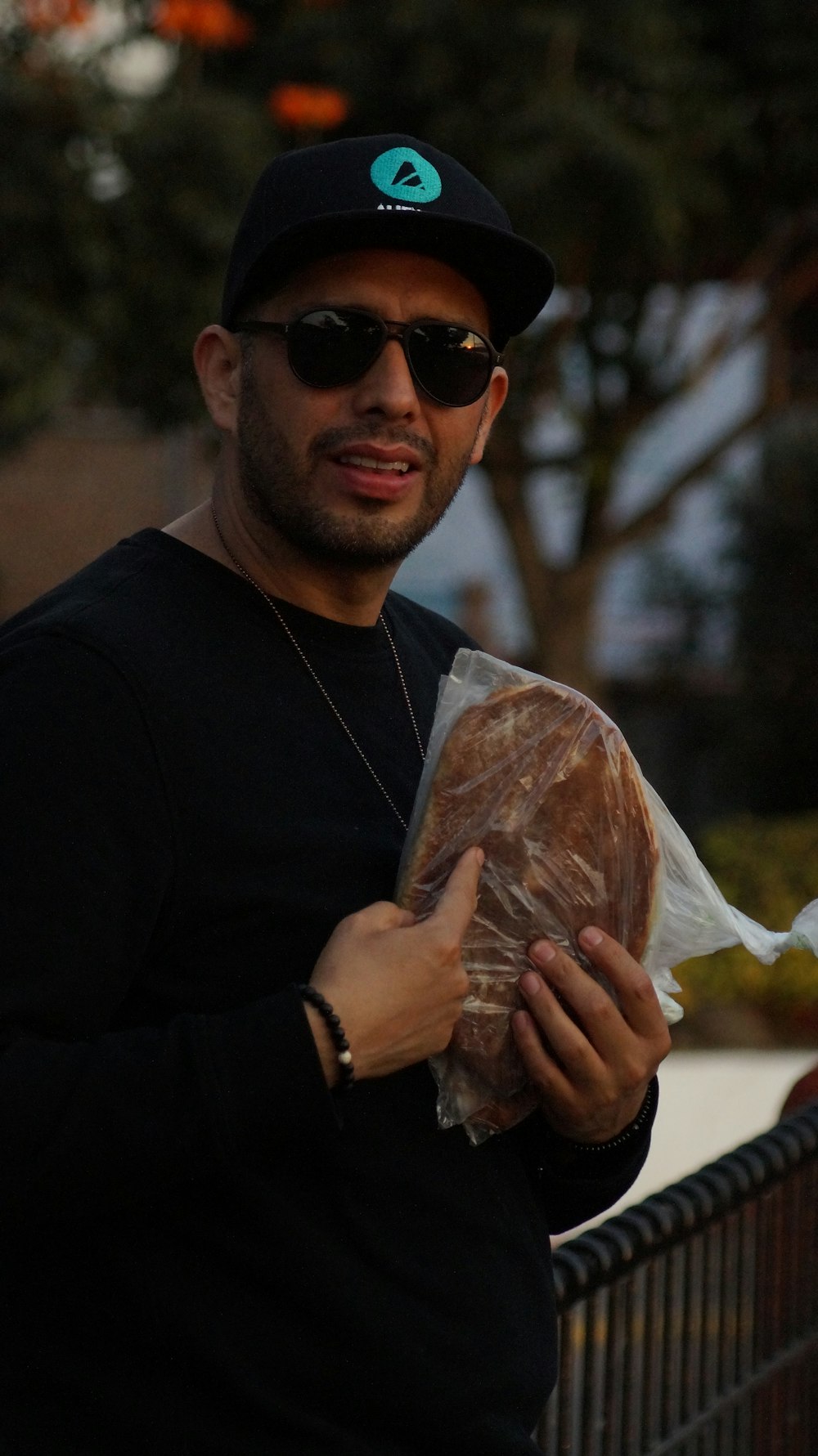 man in black long sleeve shirt holding white plastic bag