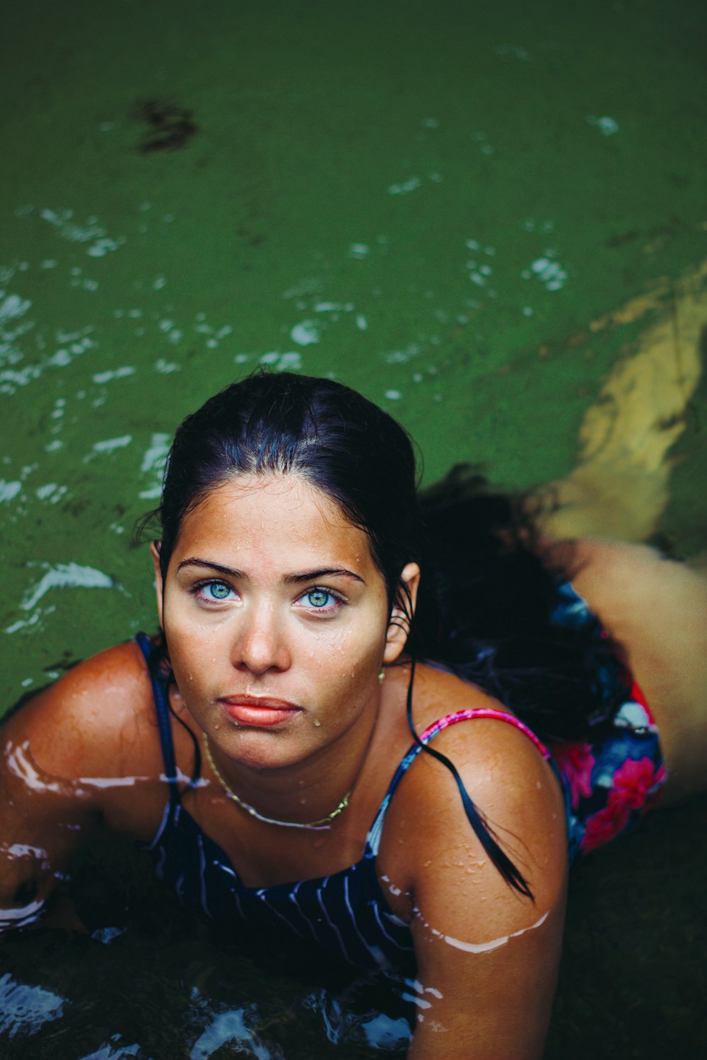 woman in purple bikini top lying on water