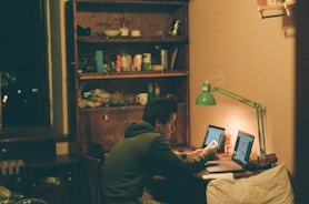 man in black jacket using laptop computer
