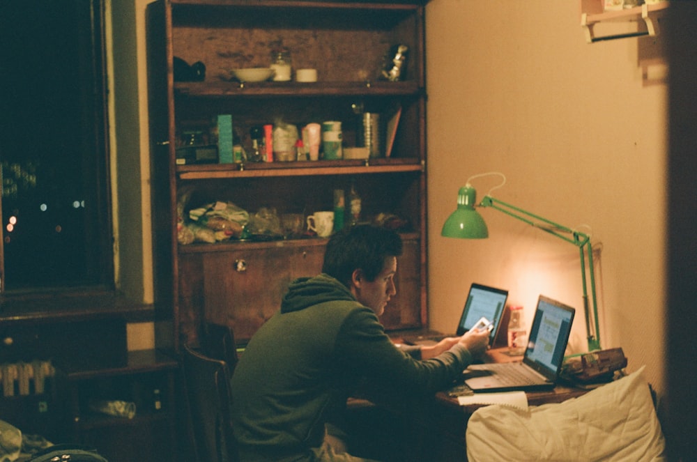 man in black jacket using laptop computer