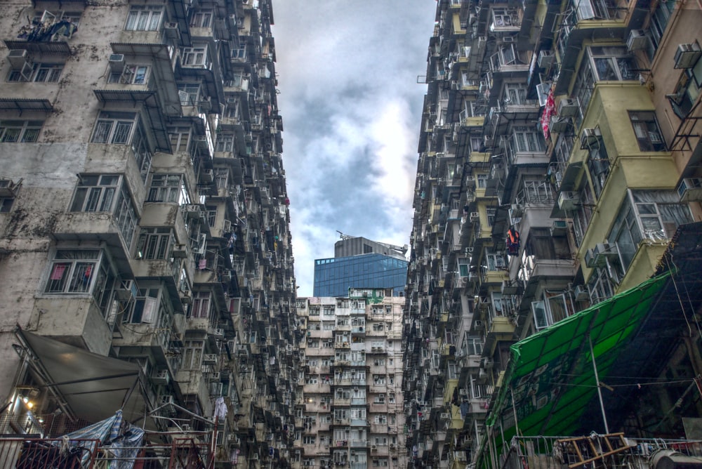 low angle photography of high rise buildings under white clouds during daytime