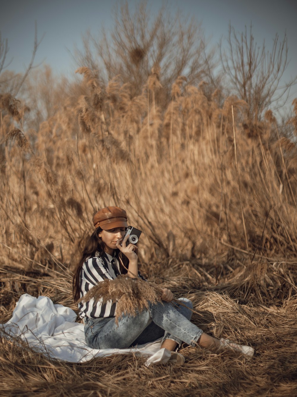 woman in black and white stripe long sleeve shirt sitting on brown rock