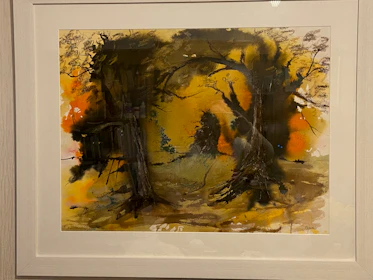A framed abstract painting with deep forest green and muted clay brushstrokes against a soft charcoal wall.