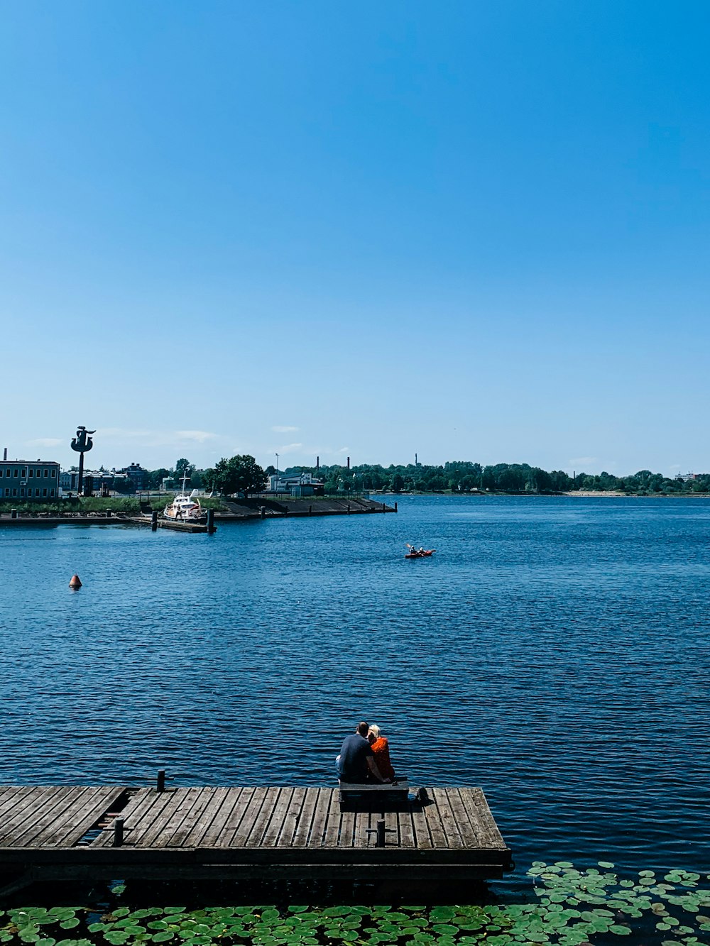 man sitting on brown wooden dock during daytime