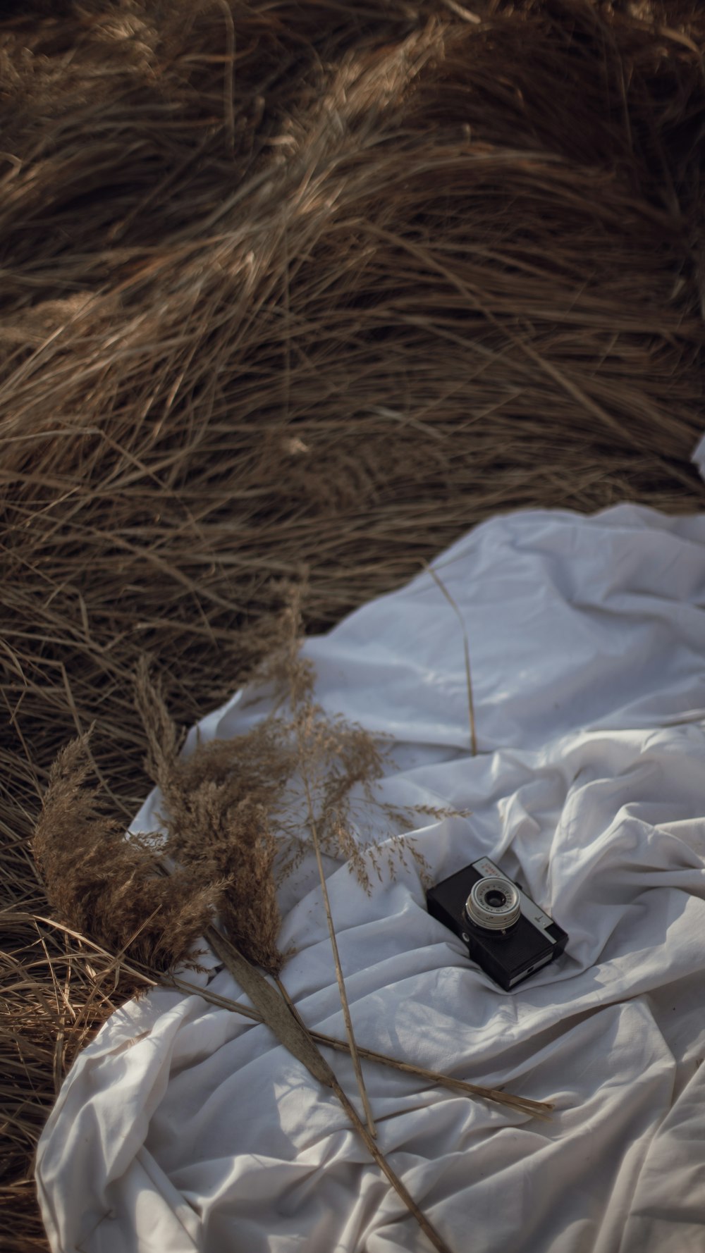 white textile beside black and gray camera