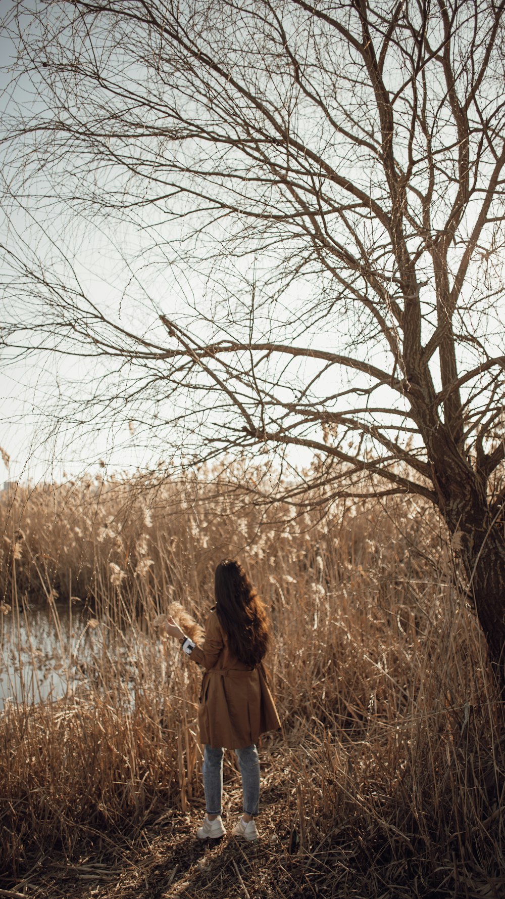 woman in black and white dress standing on brown grass field during daytime