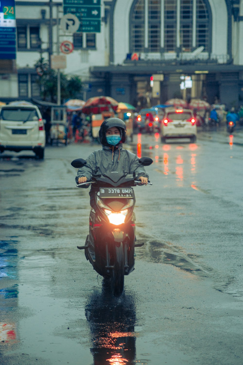 man in black jacket riding red motorcycle on road during daytime