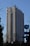 A tall hotel building with numerous windows and a logo labeled 'Hotel Marinela' near the top. In the foreground, there are bare trees and a sign with a subway symbol and street name written in both Cyrillic and English. The sky is clear and blue, suggesting it is daytime.