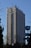 A tall hotel building with numerous windows and a logo labeled 'Hotel Marinela' near the top. In the foreground, there are bare trees and a sign with a subway symbol and street name written in both Cyrillic and English. The sky is clear and blue, suggesting it is daytime.
