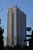 A tall hotel building with numerous windows and a logo labeled 'Hotel Marinela' near the top. In the foreground, there are bare trees and a sign with a subway symbol and street name written in both Cyrillic and English. The sky is clear and blue, suggesting it is daytime.