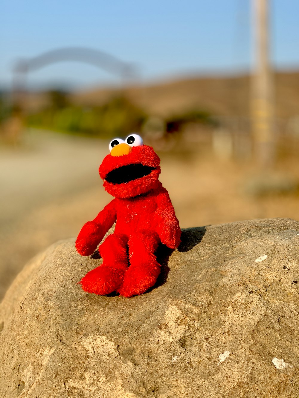 red and white plush toy on brown rock