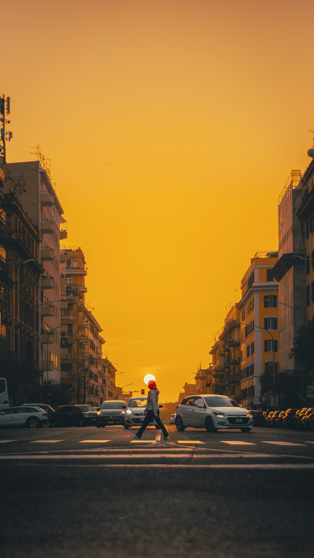 man in gray jacket and black pants walking on street during sunset
