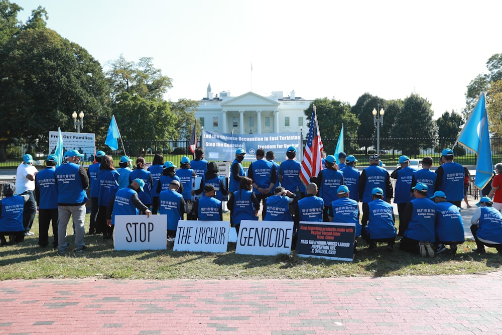 group of people wearing blue and black jacket standing on green grass field during daytime