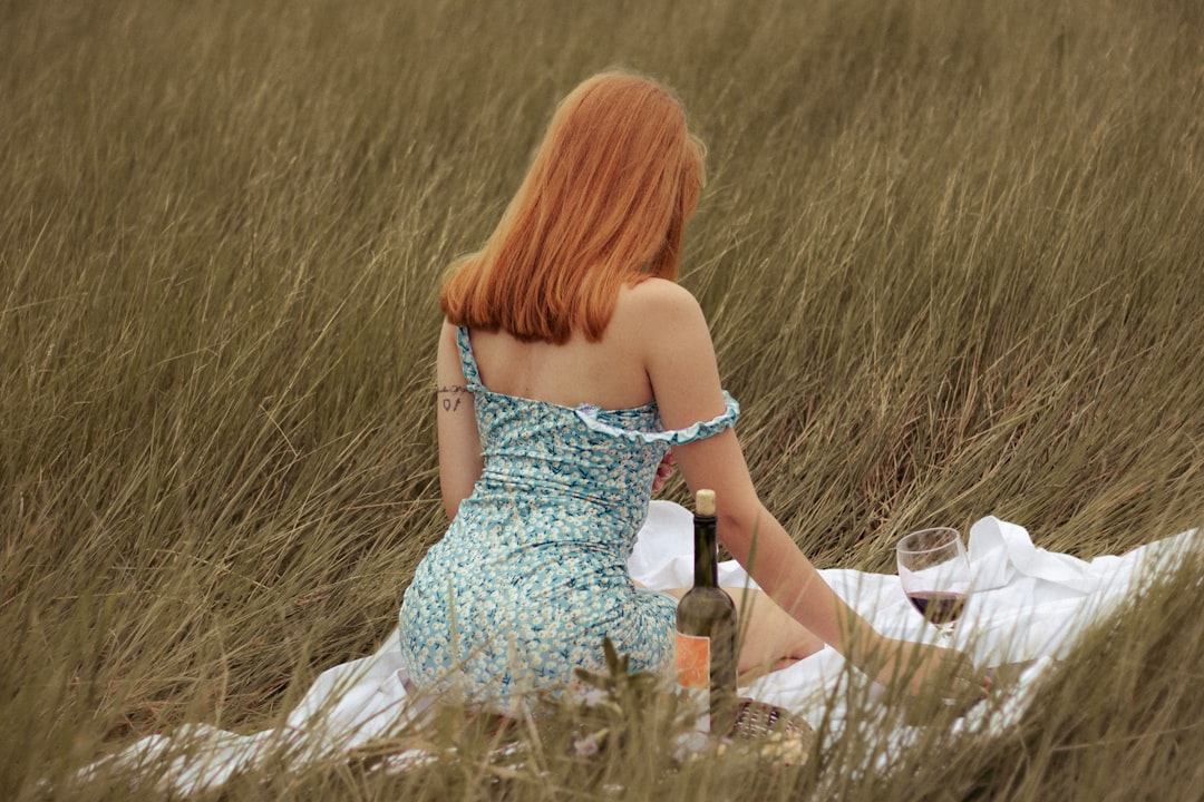 woman in white tube dress holding glass bottle