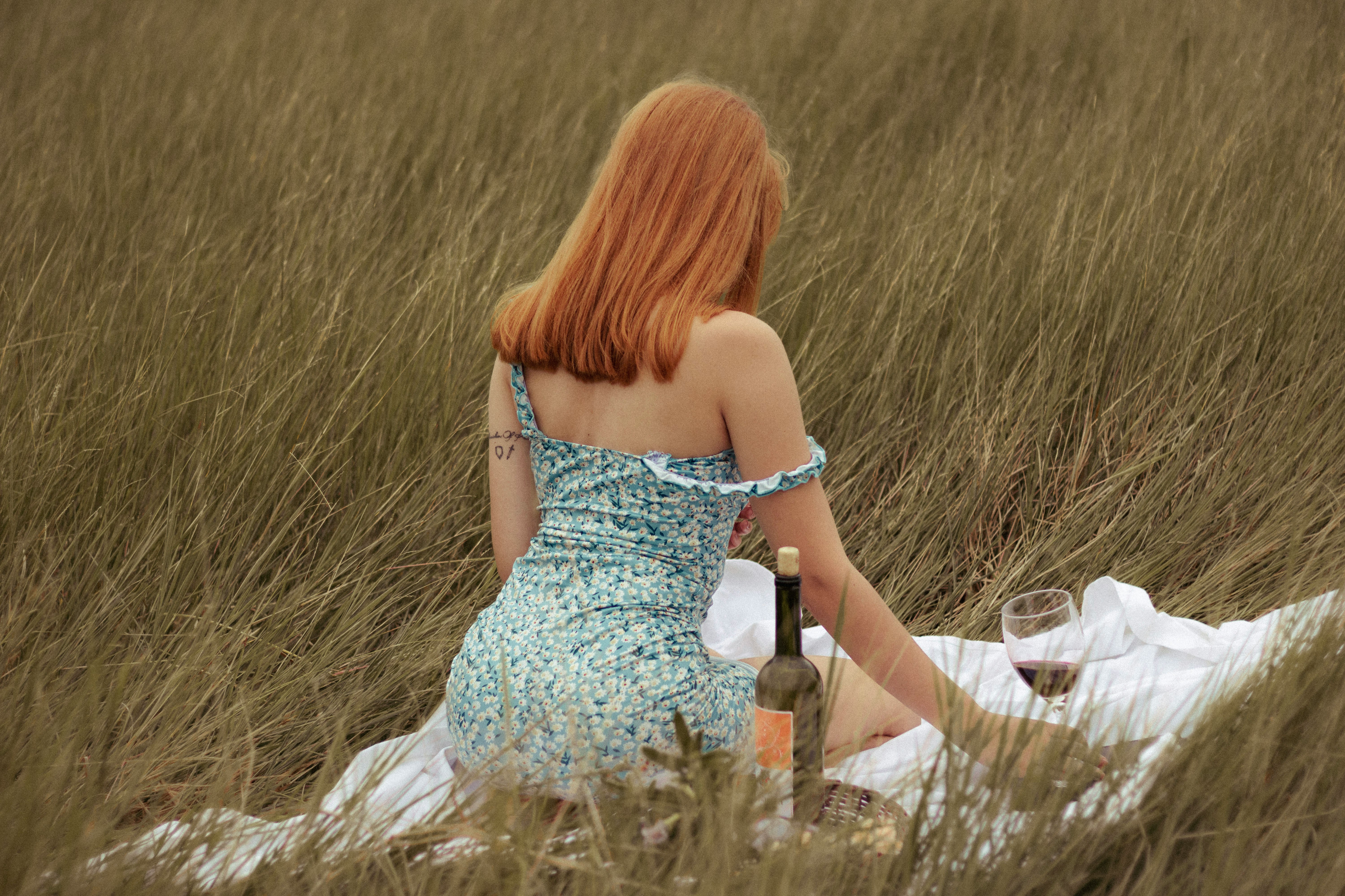 woman in white tube dress holding glass bottle