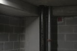 Close-up of radon detector placed near a basement wall.