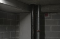 Technician performing leak detection with specialized equipment in a basement.