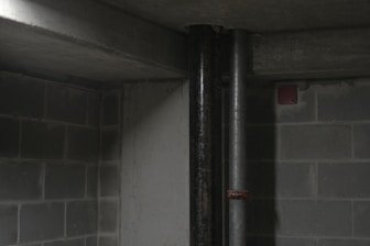 Professional setting up radon detection equipment in a basement