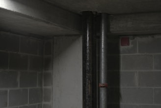 A plumber inspecting a sump pump in a basement.