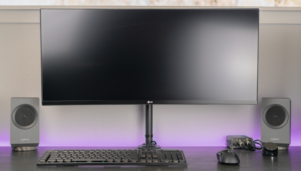 black computer keyboard beside black flat screen computer monitor