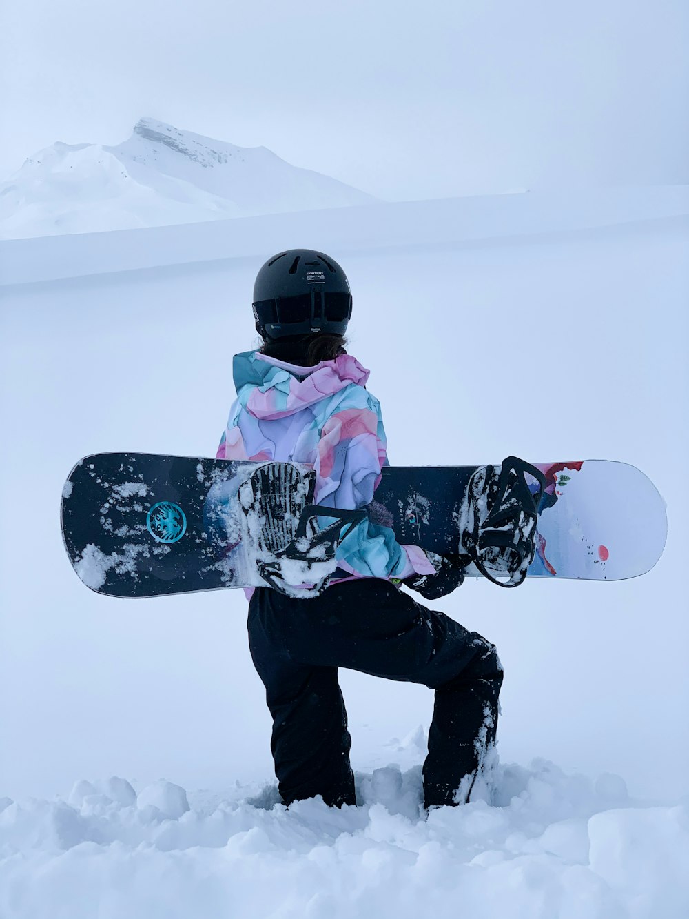 person in black pants and pink jacket riding white snowboard