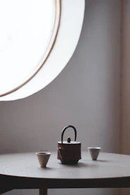 Minimalist scene of a serene morning with a cup of tea beside a window and a bottle of hair supplements.
