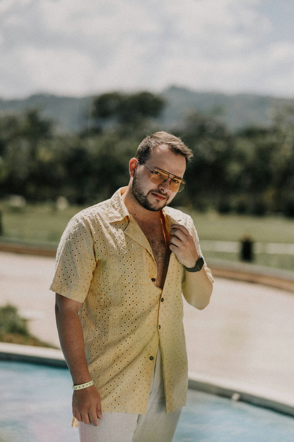 man in beige button up shirt standing on road during daytime