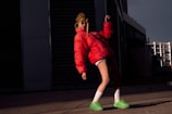 Model wearing a vibrant, lightweight running jacket against a city backdrop.