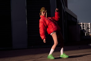 Model wearing a vibrant, lightweight running jacket against a city backdrop.