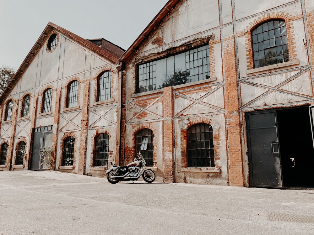 black motorcycle parked in front of brown concrete building