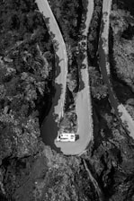 A winding mountain road viewed from inside a van windshield.