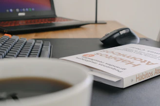 A vibrant desk setup with Spanish language books, a notebook, and a laptop open to a grammar summary page.