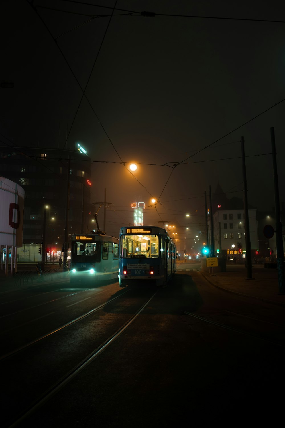 white and green train on rail road during night time