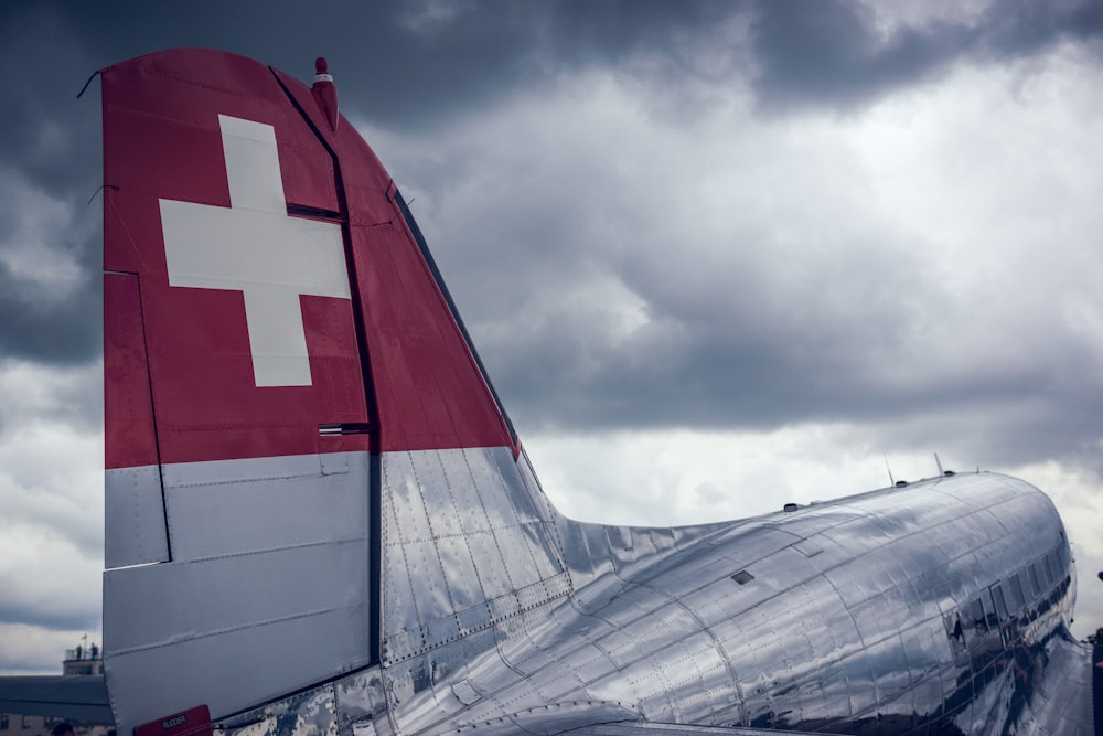 red and white airplane under cloudy sky during daytime