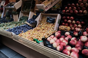 A vibrant display of fresh colorful fruits arranged in wooden crates at a market stall.