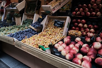 A vibrant display of fresh colorful fruits arranged in wooden crates at a market stall.