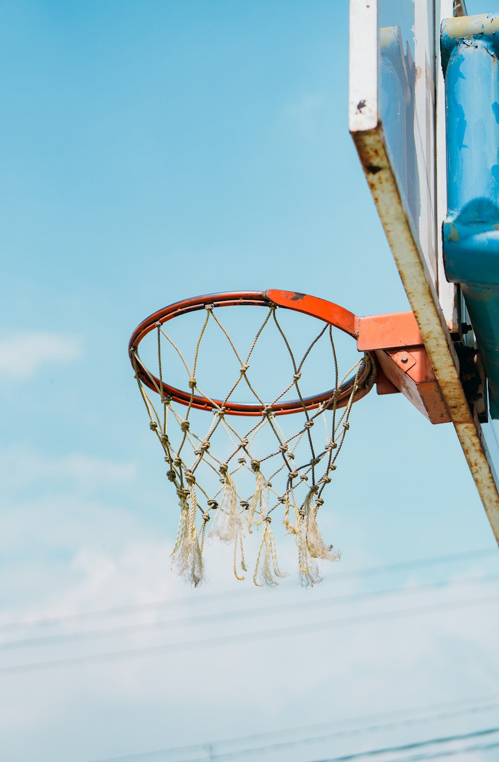 Aro de baloncesto naranja bajo el cielo azul durante el día