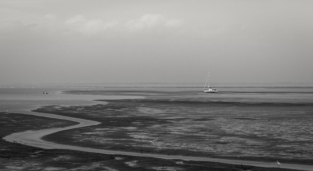 white sailboat on sea under white sky during daytime