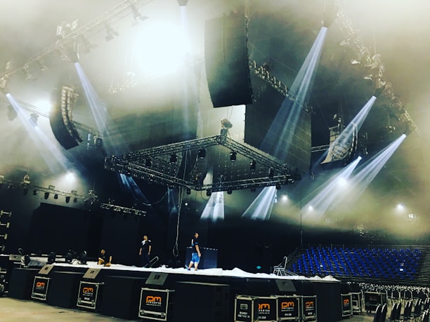 A technician carefully installing bright stage lights for a live music venue.