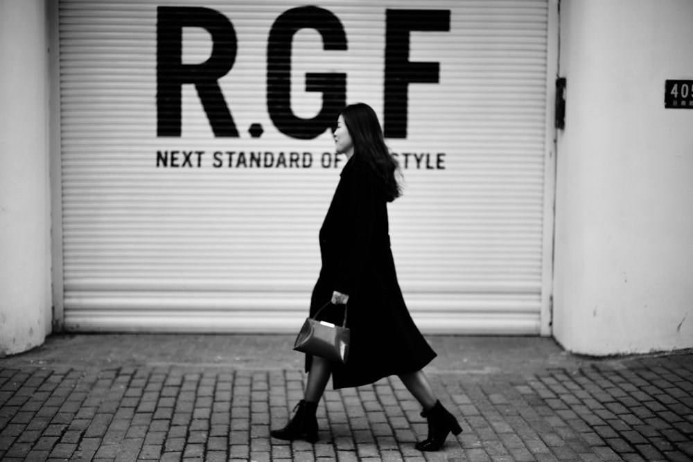 woman in black long sleeve dress walking on sidewalk