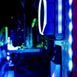 A close-up view of the internal components of a computer, featuring LED lights and cooling fans. The image is lit with blue and green hues, highlighting the sleek, modern design of the hardware.
