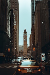 cars on road between high rise buildings during daytime