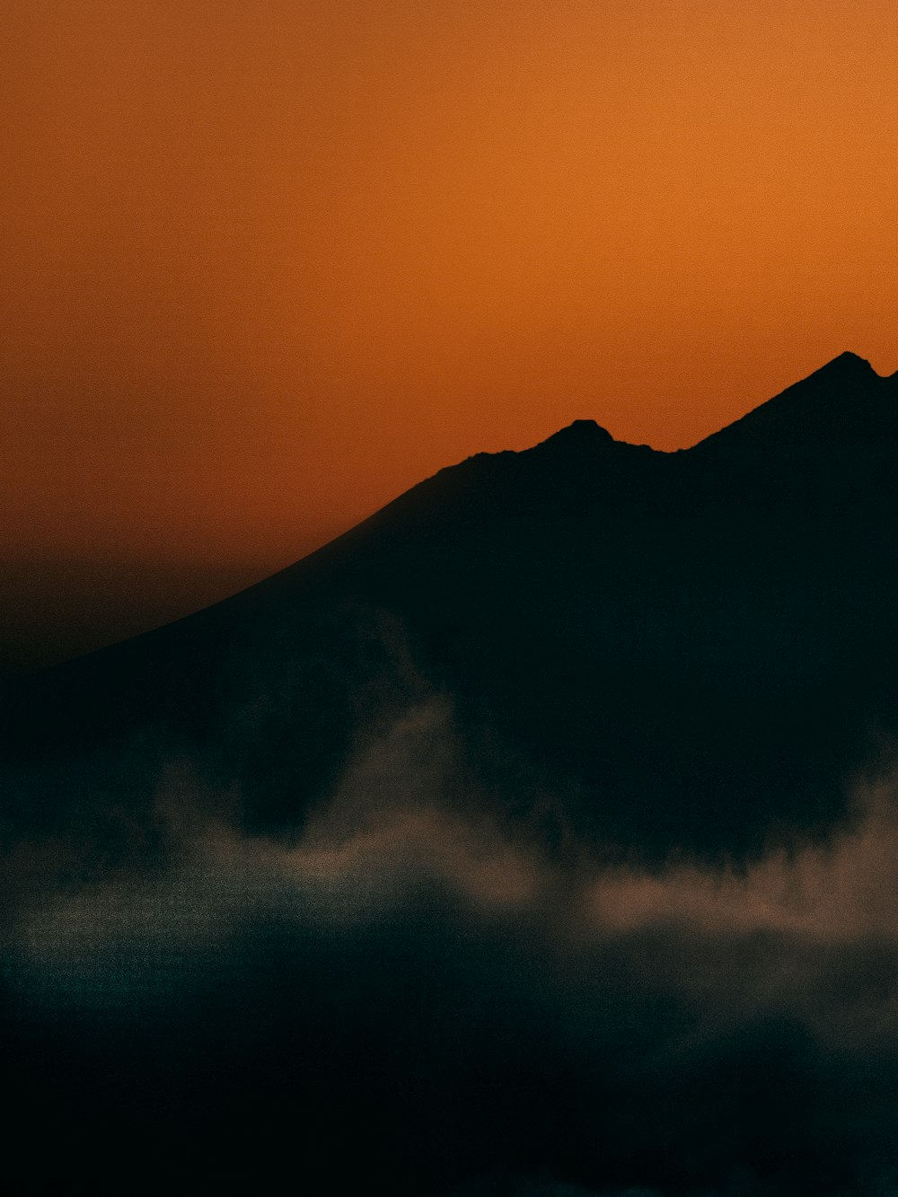 silhouette of mountain under blue sky during daytime